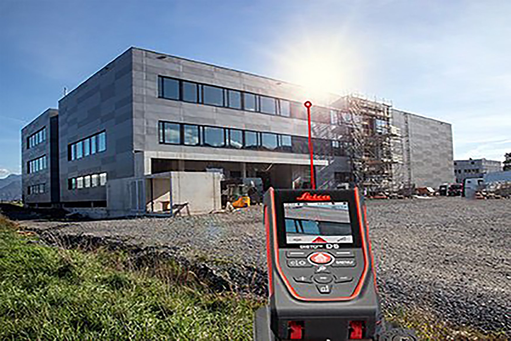 Le bord supérieur d'un bâtiment est visé avec le Leica DISTO D5. La cible apparaît sur l'écran du viseur du télémètre laser.  