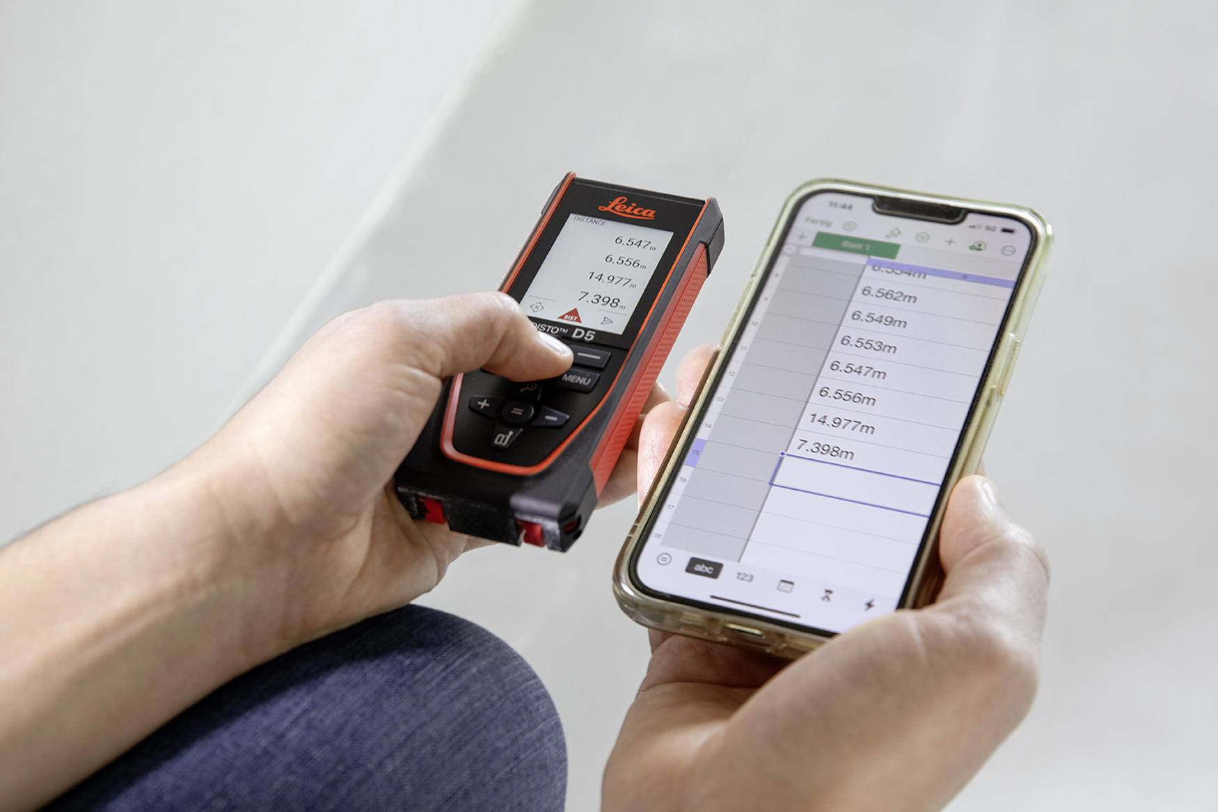 Leica DISTO D5 laser measure with measurement results in the display. The same measurement results appear in the table on the smart phone 