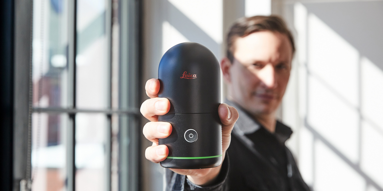 man holding the Leica BLK360 laser scanner towards the camera