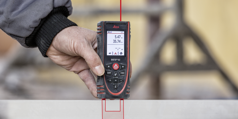 With the end piece of the Leica DISTO X3 fully extended, a distance is measured from a slot. 