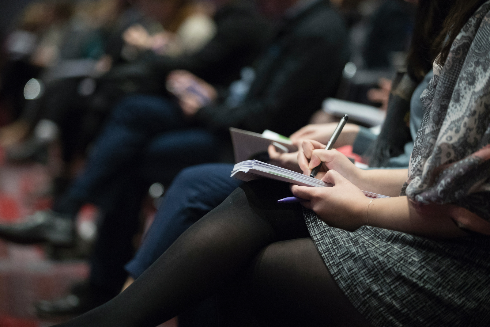 Person writing notes at a seminar