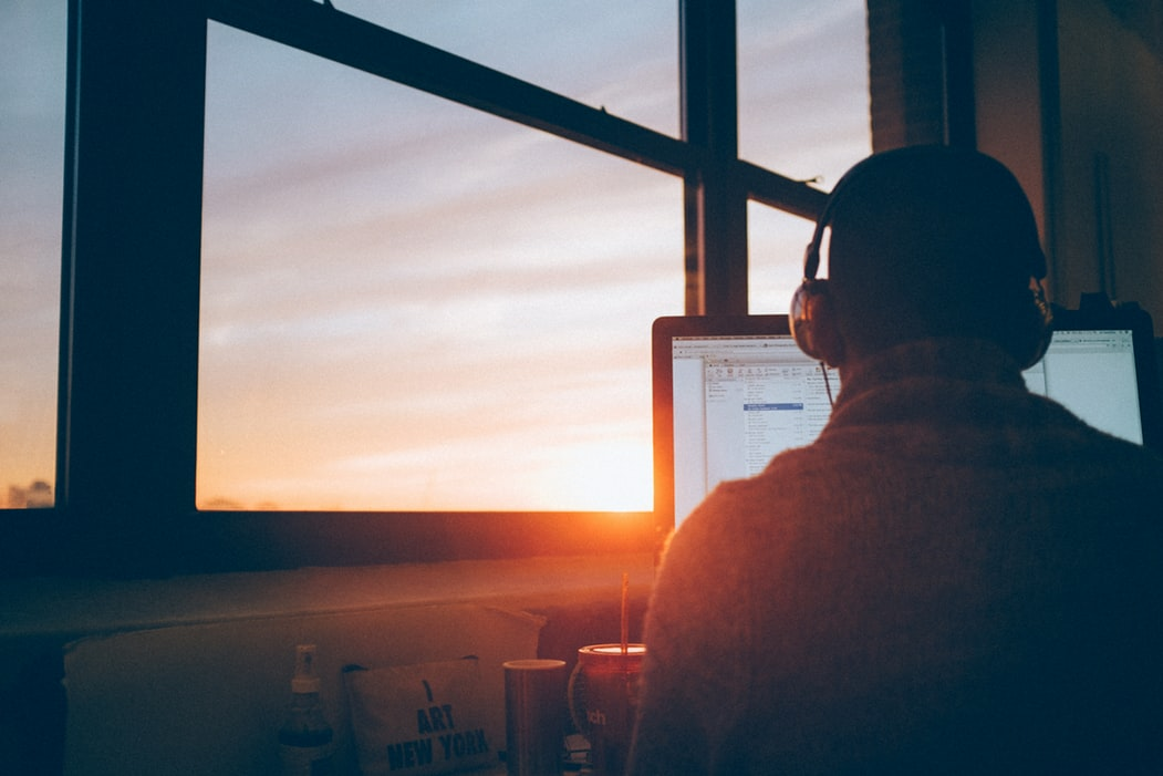 Man wearing headphones sitting at a computer