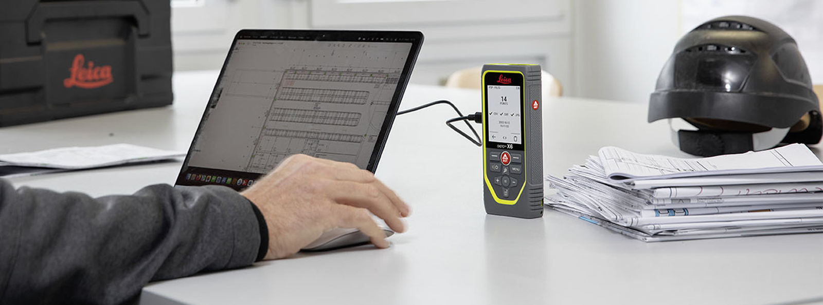 Individual utilizing a laptop connected to a DISTO X6