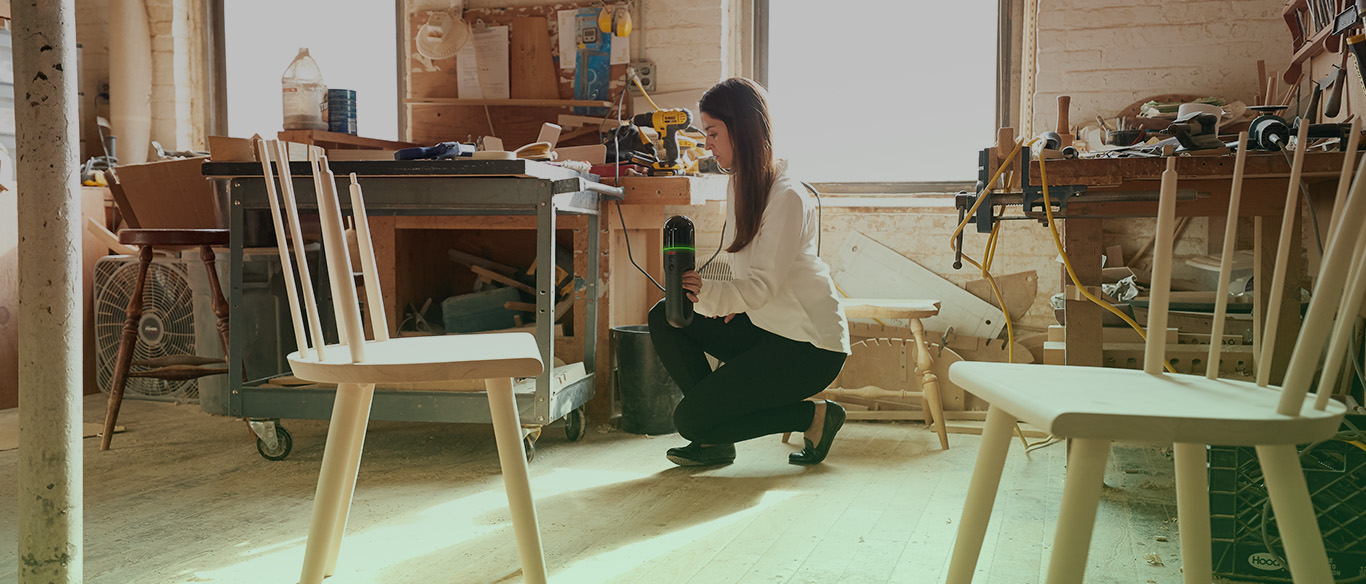 Woman crouched down, scanning a room with the BLK2GO