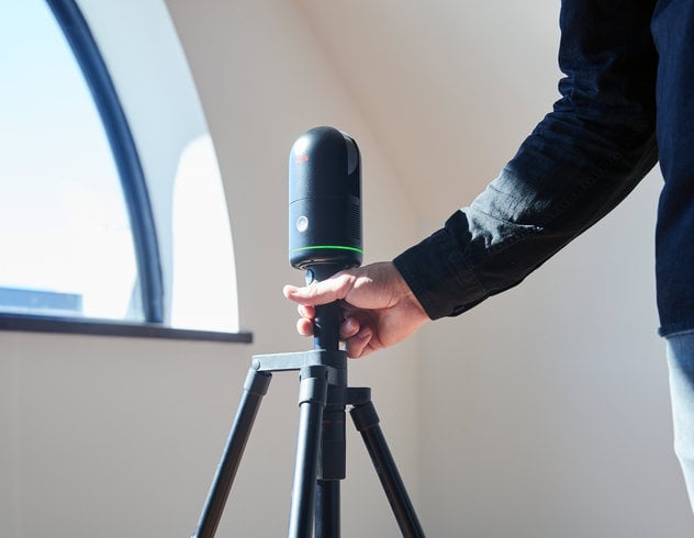 Person holding a BLK360 on a tripod